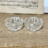 Two clear glass bowls on a textured fabric surface with sheet music in the background.