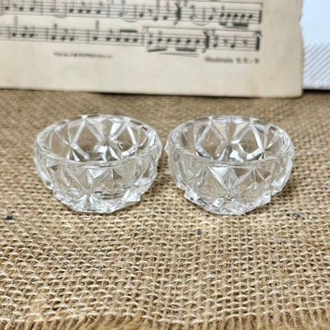 Two clear glass bowls on a textured fabric surface with sheet music in the background.